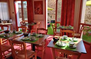 a restaurant with wooden tables and chairs with dishes on them at Hotel La Bosselle in Saint-Philbert-de-Grand-Lieu