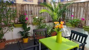 a green table with a vase of flowers on a patio at Estudio Maignon in Barcelona