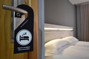 un cartel en la puerta de una habitación con cama en Hotel Alda Centro Oviedo, en Oviedo