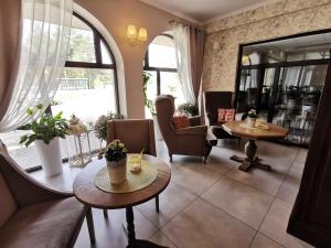 a living room with chairs and tables and a large window at Noclegi Pod Borem in Kępno