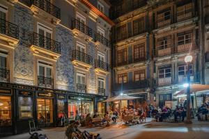 een groep mensen die 's nachts buiten in een straat zitten bij Port Wine Flats in Vila Nova de Gaia