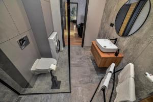 La salle de bains est pourvue de toilettes, d'un lavabo et d'un miroir. dans l'établissement Portowa Art, à Nowa Sól