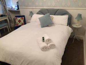 a bed with two rolled towels on it at Arisaig Guest House in Perth