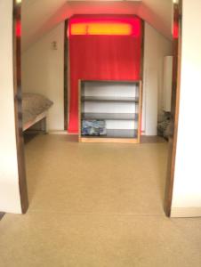 a room with two bunk beds and a red curtain at Small, cute and cozy little holiday home in Hippolytushoef