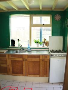 a kitchen with a sink and a stove and a window at Small, cute and cozy little holiday home in Hippolytushoef +1 photo