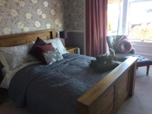 Arisaig Guest House في بيرث: غرفة نوم بسرير كبير وكرسي