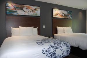 Habitación de hotel con 2 camas y 2 monitores en Vacation Lodge, en Pigeon Forge