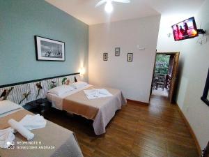a hotel room with two beds and a hallway at Pousada Ipoema in Ipoema