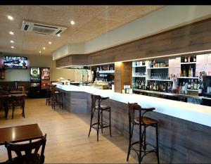 a bar with bar stools and tables in a restaurant at Hotel El Peregrino in Estépar