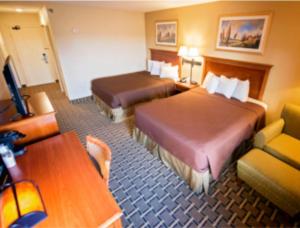 una camera d'albergo con due letti e un tavolo di Brookings Inn a Brookings