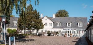 uma grande casa branca com muitas janelas em Hotel Knudsens Gaard em Odense