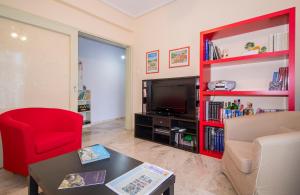 a living room with a red book shelf and a television at Laconian Collection Amalias in Sparti