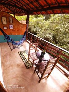 a porch with a hammock and a table and chairs at Pousada Ipoema in Ipoema