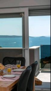 una mesa con sillas y una mesa con vistas al océano en Villa Helena, en Trogir
