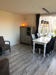 une salle à manger avec une table et des chaises blanches dans l'établissement Wadanders, à Hollum