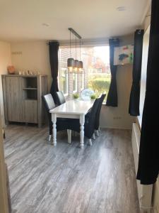 une salle à manger avec une table et des chaises blanches dans l'établissement Wadanders, à Hollum