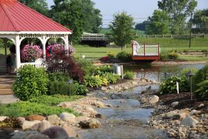 a garden with a bridge over a river with a bridge at Berlin Resort in Millersburg
