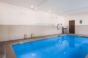 a large swimming pool with blue water in a room at La Quinta by Wyndham Auburn in Auburn