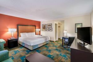 um quarto de hotel com uma cama e uma televisão de ecrã plano em La Quinta by Wyndham Meridian em Meridian
