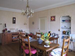 a kitchen and dining room with a table and chairs at La Tourelle des Echelles in Lésigny
