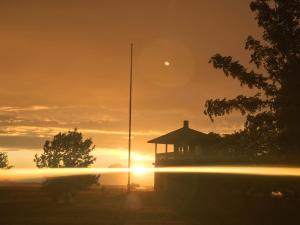 una puesta de sol con un cenador en un campo en Puise Nina Guest House, en Puise