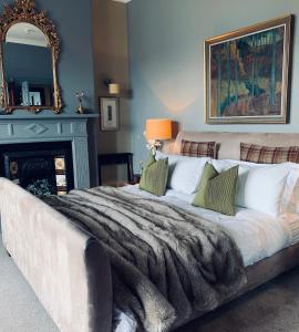 a bedroom with a large bed with a mirror and a fireplace at No.20 Boutique B&B in Helensburgh