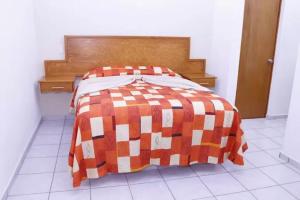 拉巴斯Hotel Salvatierra的一张橙色和白色的床铺