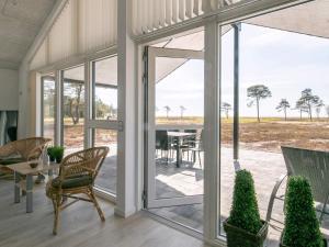 Habitación con puertas de cristal, mesa y sillas. en 14 person holiday home in L s, en Læsø