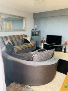 a living room with a couch and a television at CyCy Apartment in Aberdeen