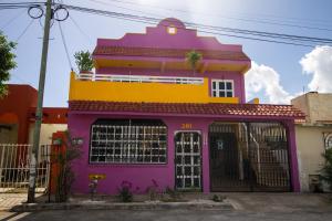 a pink and yellow house with a purple at Casa Zac Nicte Mx-Estudio SISAL in Cancún