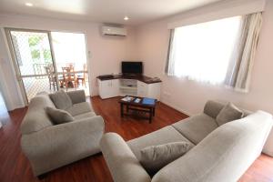 ein Wohnzimmer mit 2 Sofas und einem TV in der Unterkunft Moana Sands Beachfront Villas in Rarotonga