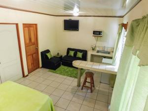 Habitación pequeña con sofá y mesa. en Hotel Amjeco, en San Isidro