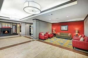 eine Lobby mit roten Möbeln und einem Kamin in der Unterkunft Holiday Inn Express Hotel & Suites Floresville, an IHG Hotel in Floresville