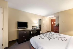 a hotel room with a bed and a flat screen tv at Sleep Inn & Suites Ruston Near University in Ruston