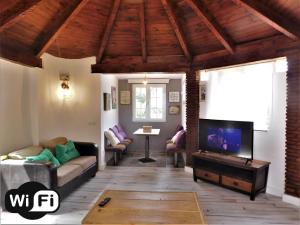 Bungalow Marbella (San Pedro Alcantara) في مربلة: غرفة معيشة مع أريكة وتلفزيون