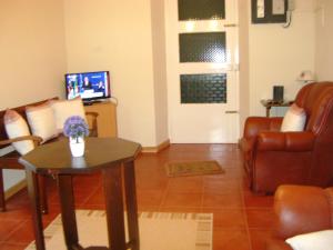 a living room with a table and a couch and a television at Casa d'Amália in Ginetes