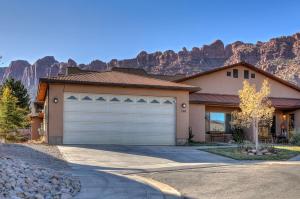 uma casa com garagem em frente a uma montanha em Oleander Place em Moab