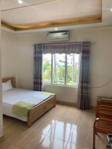 1 dormitorio con cama y ventana en Nhà Nghỉ Diễm Quỳnh, en Noi Bai