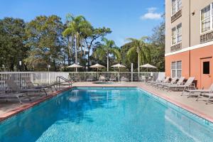 una piscina con sillas y un edificio en Holiday Inn Express & Suites Sarasota East, an IHG Hotel, en Sarasota