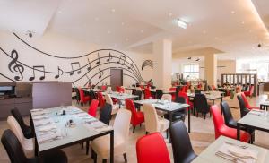 彰化市的住宿－彰化福泰商務飯店，用餐室配有桌子和红色椅子