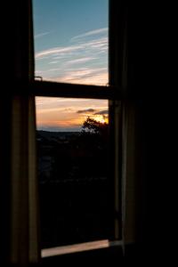 a view of a sunset through a window at Pousada San Clemente Centro in Gramado