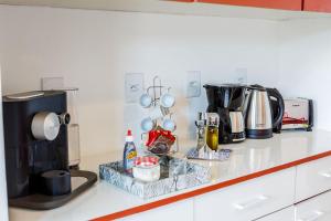 a kitchen counter with a coffee maker and a microwave at Aluguel de Suítes por Temporada em Alto de Pinheiros in Sao Paulo