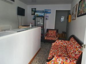 een woonkamer met een bed en een bank bij Victoria's Gennie Bay Village Hostal in San Andrés