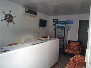 una camera con bancone, TV e mensola di Victoria's Gennie Bay Village Hostal a San Andrés