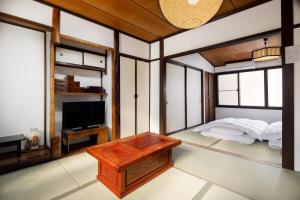Habitación con cama y TV. en Tsumugi Shichijo-Kagiyacho, en Kioto