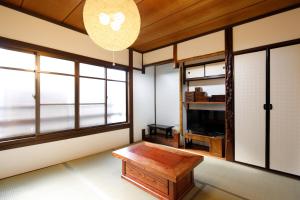 sala de estar con mesa de centro y ventanas en Tsumugi Shichijo-Kagiyacho, en Kioto