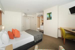 a hotel room with a bed and a table and a desk at Quality Hotel Lincoln Green in Auckland +58 photos