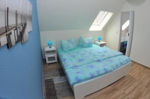 a bedroom with a bed with blue sheets and blue pillows at Ferienhaus Müritzzauber / OG-Appartement in Marienfelde