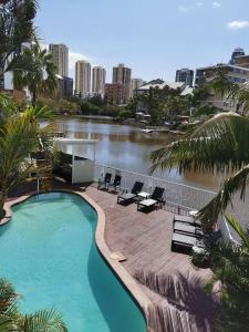 a swimming pool with chairs and a body of water at Surfers Del Rey in Gold Coast