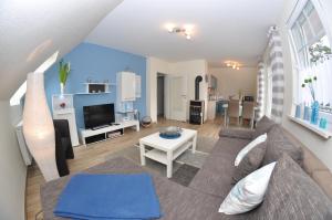 a living room with a couch and a tv at Ferienhaus Müritzzauber / OG-Appartement in Marienfelde